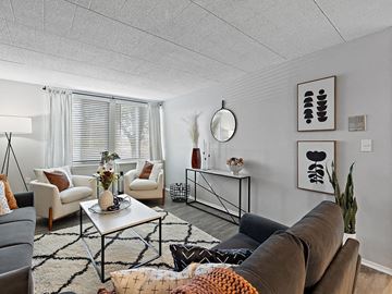 Southgate townhouse for rent - A living room with a brown couch, a white coffee table, and a rug with a geometric pattern.