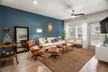 Dallas apartment for rent - A living room with a brown rug and a white couch.