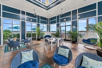 A sunroom with blue chairs and a table.