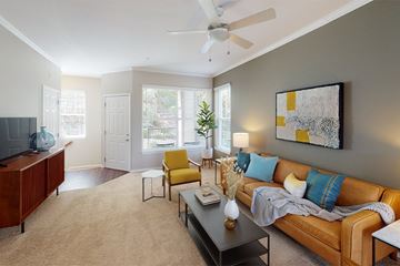 Sammamish apartment for rent - A living room with a brown couch, a yellow chair, and a painting on the wall.