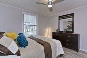 Tampa apartment for rent - A bedroom with a bed, dresser, and mirror.