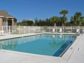 Vero Beach apartment for rent - A swimming pool surrounded by a white fence.