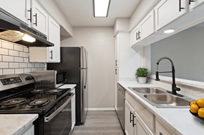 Dallas apartment for rent - A kitchen with a black stove top oven and a black refrigerator.