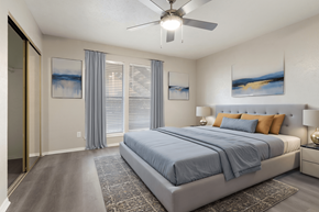 Dallas apartment for rent - A bedroom with a large bed and a ceiling fan.