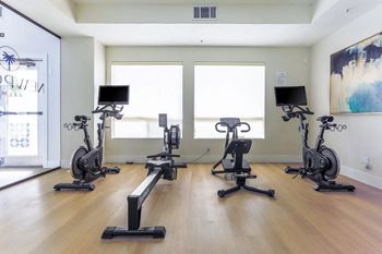 Fitness center with cardio equipment, weights, and tv's