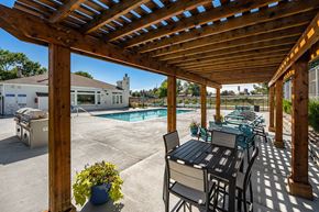 Lakewood apartment for rent - the private patio has a pergola and a pool with chairs and tables