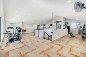 Centennial apartment for rent - A gym with orange carpeting and exercise equipment.