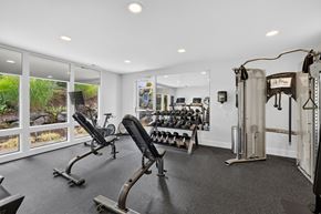 Renton apartment for rent - A gym with a row of treadmills and a row of dumbbells.