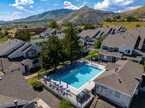 Golden apartment for rent - A swimming pool surrounded by houses with a mountain in the background.