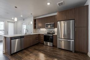 Golden apartment for rent - A modern kitchen with wooden cabinets and stainless steel appliances.