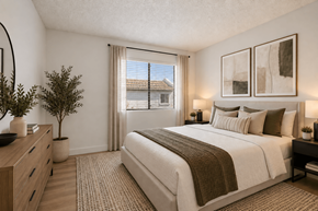 Tempe apartment for rent - A bedroom with a large bed, a dresser, and a potted plant.
