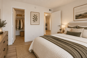 Tempe apartment for rent - A bedroom with a large bed and a closet with clothes hanging.