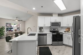 Puyallup apartment for rent - A modern kitchen with white cabinets and stainless steel appliances.