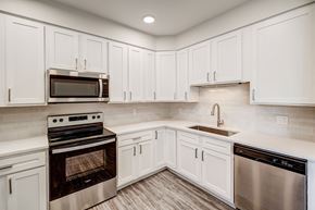 Lakewood apartment for rent - a kitchen with white cabinets and stainless steel appliances