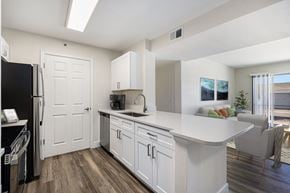 Centennial apartment for rent - A kitchen with white cabinets and a black refrigerator.