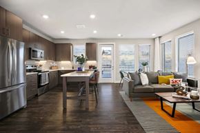 Golden apartment for rent - A modern kitchen with a dining table and a couch.