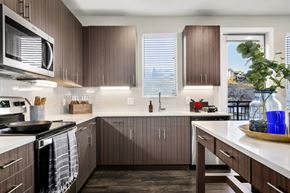Golden apartment for rent - A kitchen with brown cabinets and a white counter.