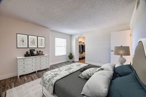 Lakewood apartment for rent - A bedroom with a bed, dresser, and a plant.