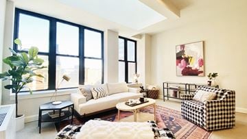 Albany apartment for rent - a living room with a couch and chairs and large windows