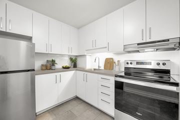 Nepean apartment for rent - A modern kitchen with white cabinets and stainless steel appliances.