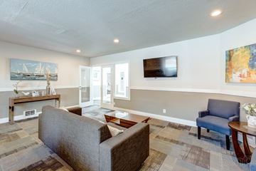 Des Moines apartment for rent - A living room with a grey couch and a painting on the wall.