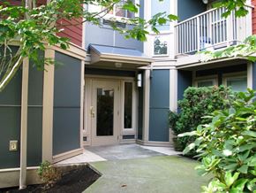Seattle apartment for rent - A building with a green bush in front of it.
