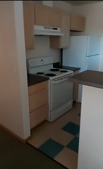 Seattle apartment for rent - A small kitchen with a white fridge and a white stove.