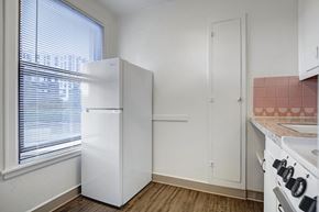 Seattle apartment for rent - A kitchen with a white refrigerator, white oven, and a pink tile backsplash.