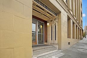 Seattle apartment for rent - The entrance to a building with a glass door and a sign above it.