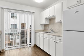 Seattle apartment for rent - A kitchen with white cabinets and a white fridge.