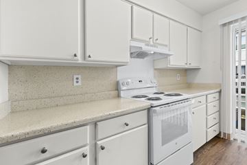 Seattle apartment for rent - A white kitchen with a stove and cabinets.