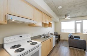 Seattle apartment for rent - A kitchen with a stove top oven and a couch.