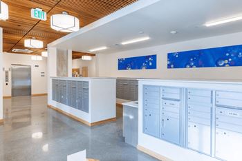 The lobby of a building with blue lockers and a counter with cabinets