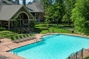 Houston apartment for rent - A large outdoor swimming pool surrounded by a black fence.
