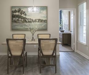 Longwood apartment for rent - A dining room with a large painting on the wall and a vase with white flowers on the table.