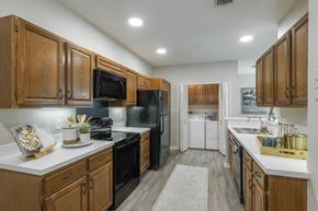 Longwood apartment for rent - A kitchen with wooden cabinets and black appliances.