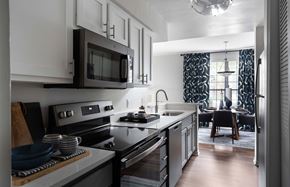 Indianapolis apartment for rent - A modern kitchen with a black stove top oven and a black microwave above the counter.
