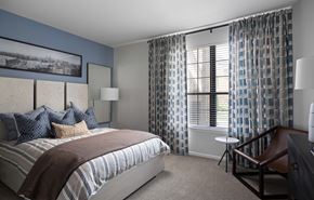 Indianapolis apartment for rent - A bedroom with a large bed and a chair.