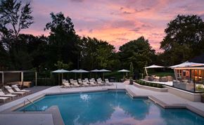 Louisville apartment for rent - A pool surrounded by trees and lounge chairs.