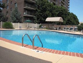 Hackensack apartment for rent - A swimming pool with a red brick border and a metal ladder.