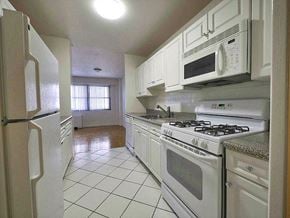 Passaic apartment for rent - a kitchen with white appliances and white cabinets