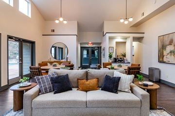 Vancouver apartment for rent - A living room with a grey couch and a round mirror on the wall.