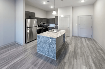 A kitchen with a marble island and stainless steel appliances 