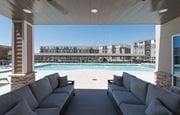 Kansas City townhouse for rent - A large outdoor seating area with a pool and apartment buildings in the background at Woodstone at Metro North Crossing Apartments, Missouri