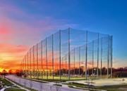 Kansas City townhouse for rent - A long, tall, transparent fence stretches across a grassy field at Woodstone at Metro North Crossing Apartments, Kansas City, 64155