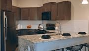 Kansas City townhouse for rent - A kitchen with a granite countertop and black chairs.
