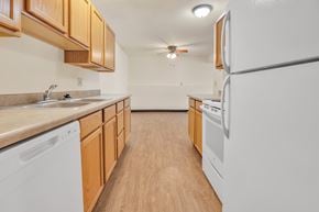 Davenport apartment for rent - A kitchen with wooden cabinets and white appliances. at Winding Hills Apartments, Davenport , Iowa
