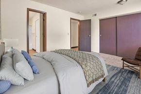 Davenport apartment for rent - A bedroom with a large bed and a chair. at Winding Hills Apartments, Davenport  52807