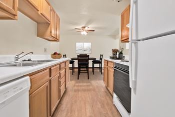 A kitchen with wooden cabinets and a white fridge.