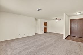 Davenport apartment for rent - A spacious room with a ceiling fan and carpeted floor. at Kimberly Club Apartments, Davenport, 52807